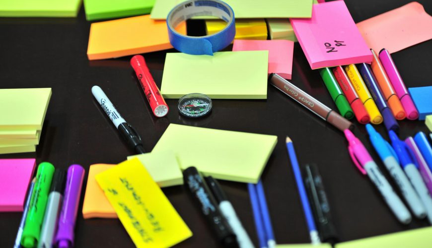 Photo of Sticky Notes and Colored Pens Scrambled on Table